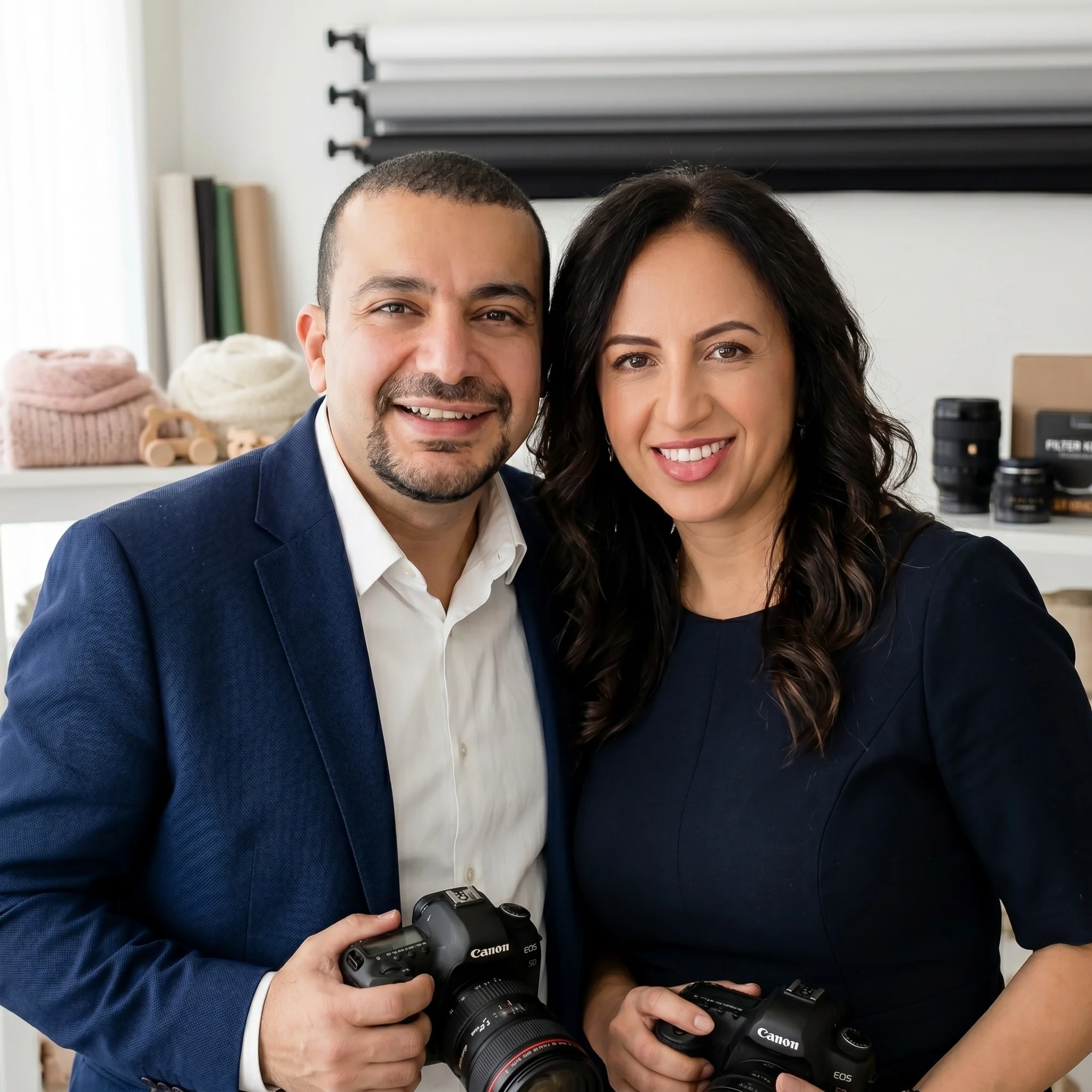 Marten and Dalia, each holding a camera, in the Faithful Photography studio